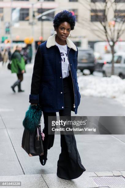 Guest wearing black flared pants, wool coat, white tshirt outside Creatures of the Wind on February 11, 2017 in New York City.