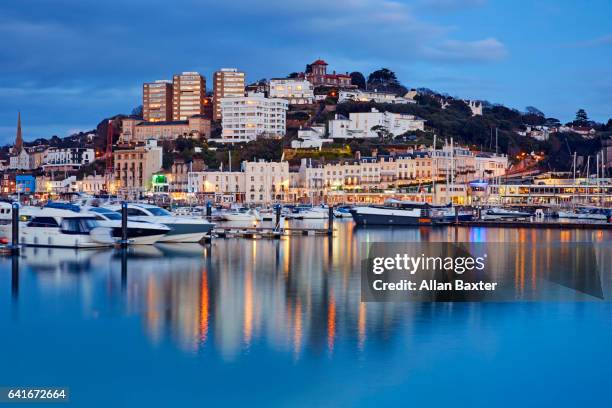 skyline of torquay marina illuminated at dusk - exeter devon stock pictures, royalty-free photos & images