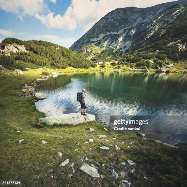 traveler standing at the lake in mountains - pirin-mountains stock pictures, royalty-free photos & images