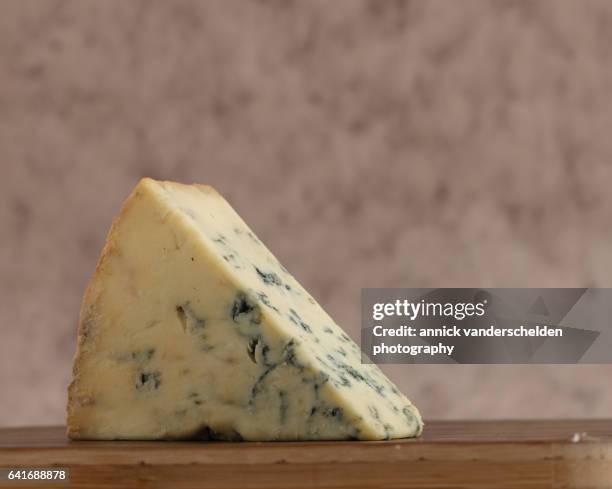 close-up piece of stilton cheese. - blue cheese crumble stock pictures, royalty-free photos & images