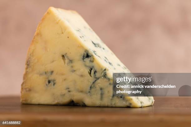 close-up piece of stilton cheese. - blue cheese stock pictures, royalty-free photos & images