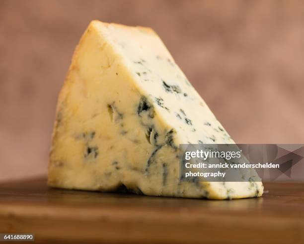 close-up piece of stilton cheese. - blue cheese crumble stock pictures, royalty-free photos & images