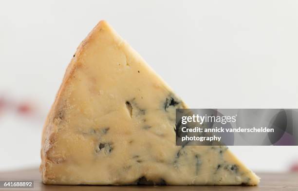 close-up piece of stilton cheese. - blue cheese crumble stock pictures, royalty-free photos & images
