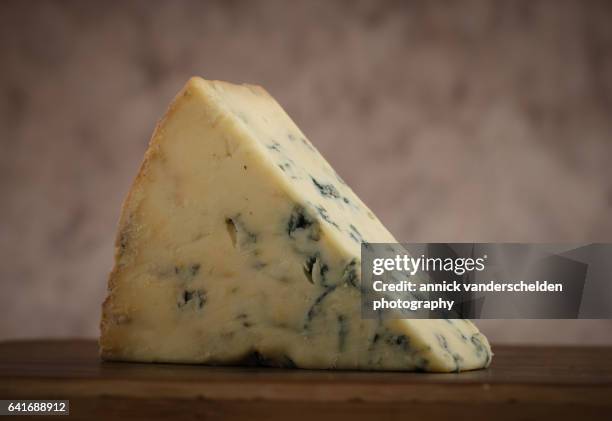 close-up piece of stilton cheese. - blue cheese crumble stock pictures, royalty-free photos & images