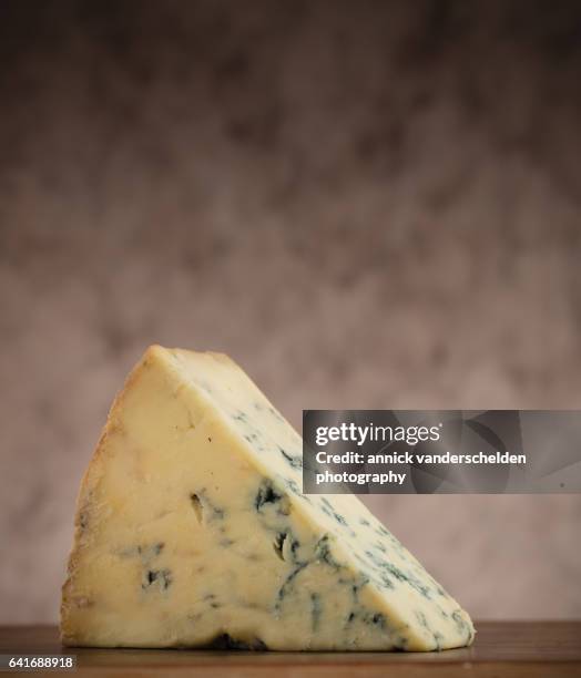 close-up piece of stilton cheese. - blue cheese crumble stock pictures, royalty-free photos & images