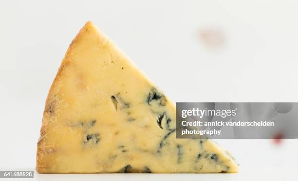 close-up piece of stilton cheese. - blue cheese crumble stock pictures, royalty-free photos & images