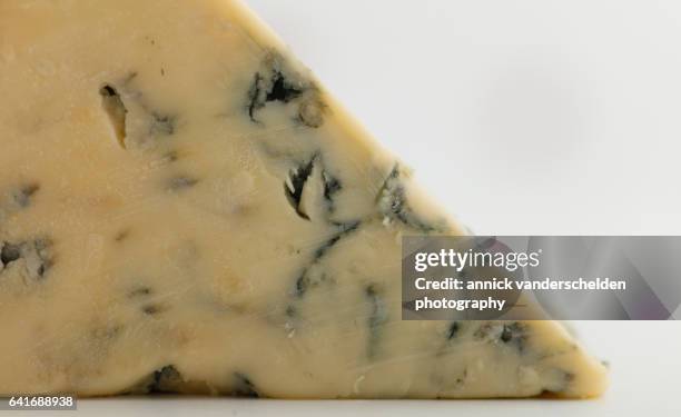 close-up piece of stilton cheese. - blue cheese crumble stock pictures, royalty-free photos & images