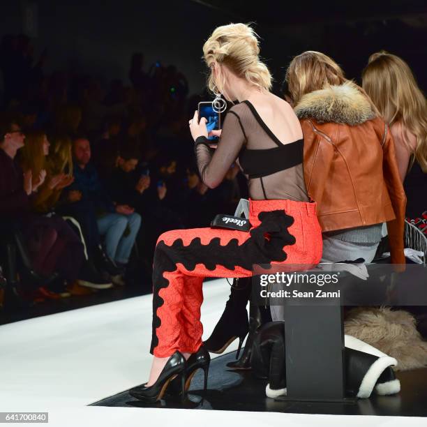 Amanda Steele takes a photo of models on the runway at the Jonathan Simkhai show during New York Fashion Week at Skylight Clarkson Sq on February 11,...