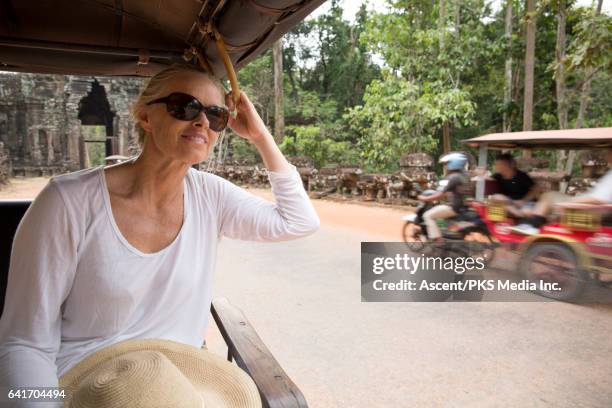 woman rides tuk tuk through ancient ruins, relaxing - rickshaw stock pictures, royalty-free photos & images