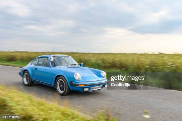 porsche 911 classic sports car driving on a country road - porsche 911 imagens e fotografias de stock