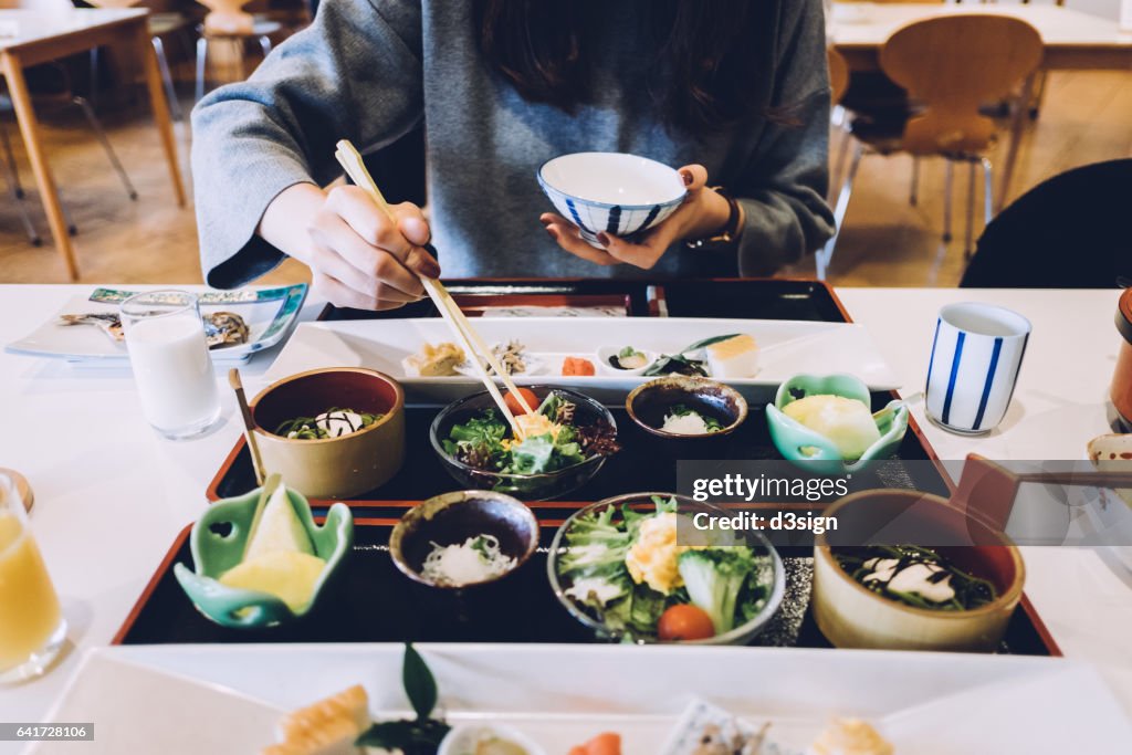 Woman is having meal in a Japanese restaurant