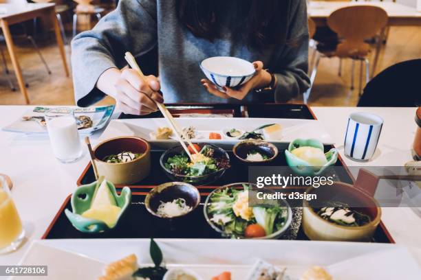 woman is having meal in a japanese restaurant - tokyo food stock pictures, royalty-free photos & images