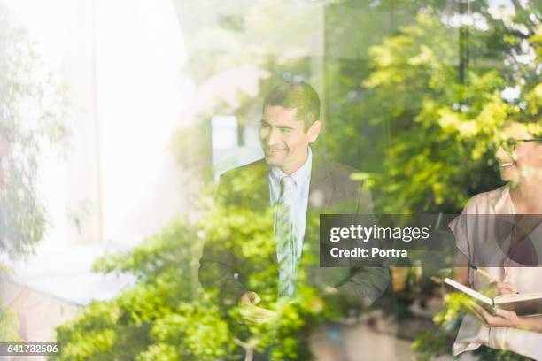 happy business people in office seen through glass - outdoor business meeting stock pictures, royalty-free photos & images