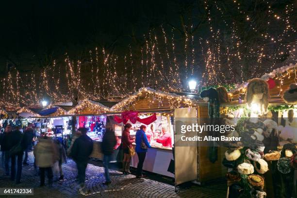 christmas market with shoppers in bruges at night - marché de noël photos et images de collection