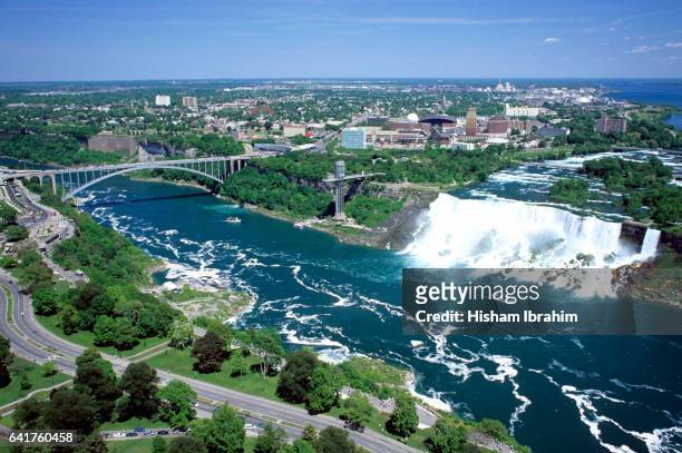 aerial view of american falls and rainbow bridge, niagara falls, new york, usa, viewed from the canadian side of the niagara river, ontario, canada - niagara falls aerial stock pictures, royalty-free photos & images