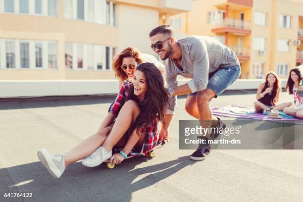 friends skateboarding on the rooftop - city to surf stock pictures, royalty-free photos & images