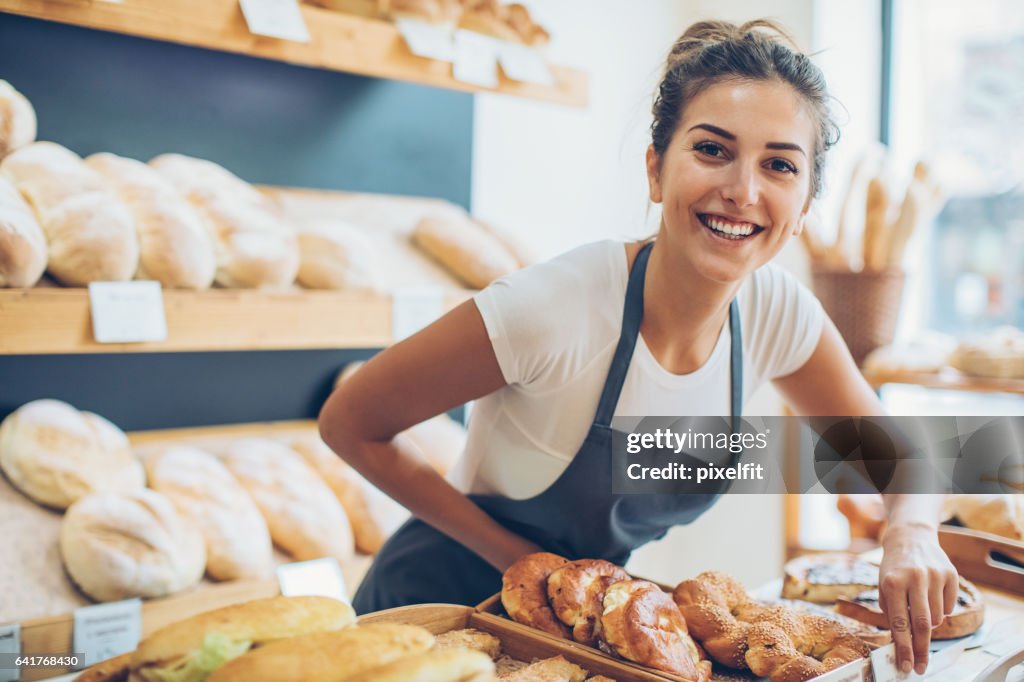 Giovane donna che vende pane e pasticceria