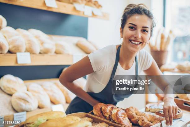 giovane donna che vende pane e pasticceria - pasticceria foto e immagini stock
