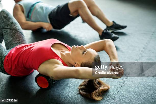 young woman doing pilates exercise at gym - warm up exercise indoor stock pictures, royalty-free photos & images