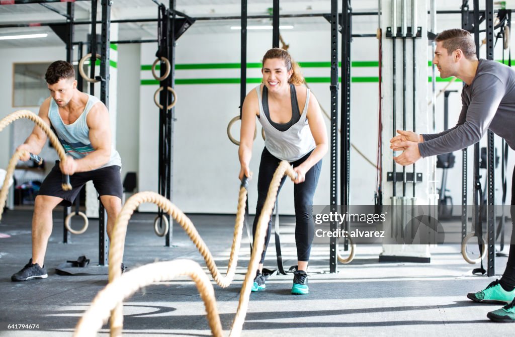 Fitness people working out with battle ropes