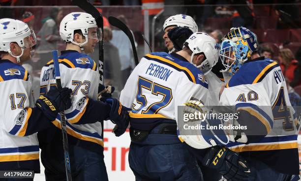 David Perron, Kenny Agostion and Jaden Schwartz congratulate Carter Hutton of the St Louis Blues after shutting out the Philadelphia Flyers 2-0 on...