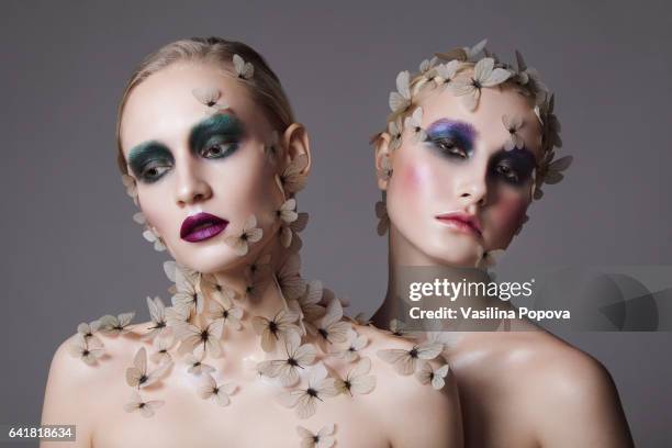 young beautiful women with butterflies on there face and neck - green eyeshadow stock pictures, royalty-free photos & images