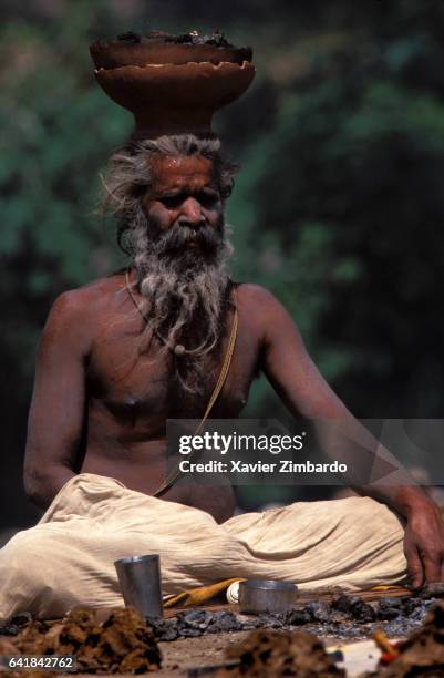 Sadhu meditates at the hottest hours of the day with embers in balance on his cranium during Maha Kumbh Mela on April 14, 1998 in Haridwar,...