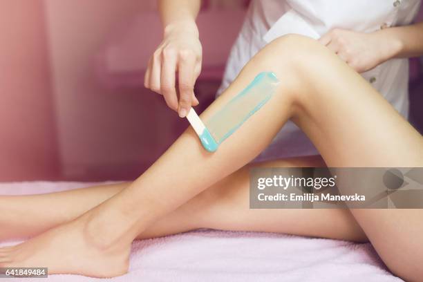 woman receiving wax hair removal - woman leg spread stock pictures, royalty-free photos & images