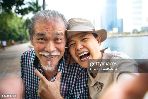momentos sincero de pareja senior juntos con unas vacaciones - thai ethnicity fotografías e imágenes de stock