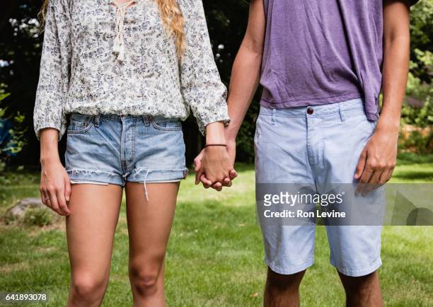 teen couple holding hands, close-up - teen boy shorts stockfoto's en -beelden