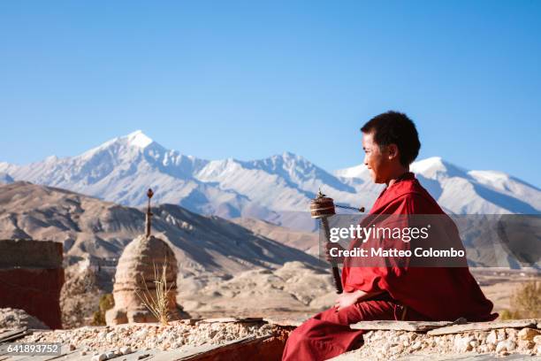 young monk spinning prayer wheel, upper mustang, nepal - tibetan culture stock pictures, royalty-free photos & images