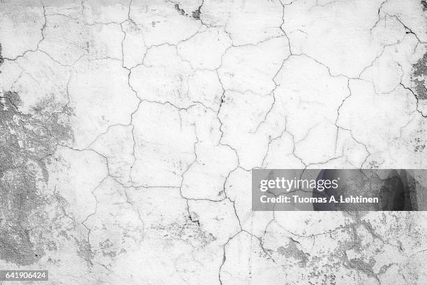 close-up of a cracked and weathered concrete wall texture in black&white. - cracked foto e immagini stock