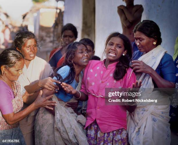 The mother of Perumal Radhakrishnan, center in blue, and his wife, 2nd right in red, cry out in grief a day after he, a member of the Dalit caste,...