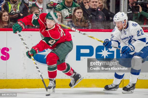 Gustav Olofsson of the Minnesota Wild passes the puck with Erik Condra of the Tampa Bay Lightning defending during the game on February 10, 2017 at...