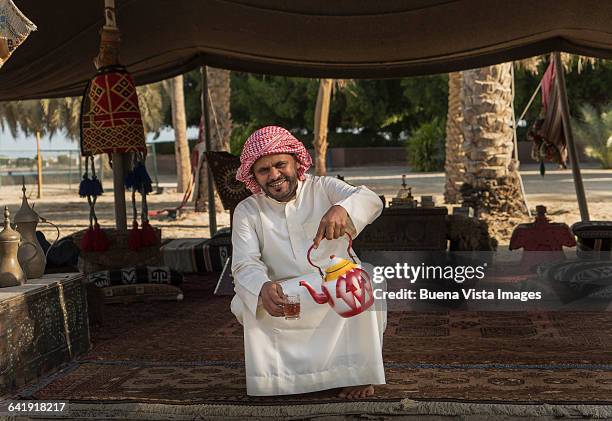 bedouin pouring tea - arabian tent stock-fotos und bilder