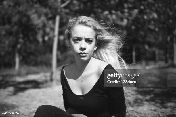 young blonde woman at forest - female looking away from camera serious thinking outside natural stock pictures, royalty-free photos & images