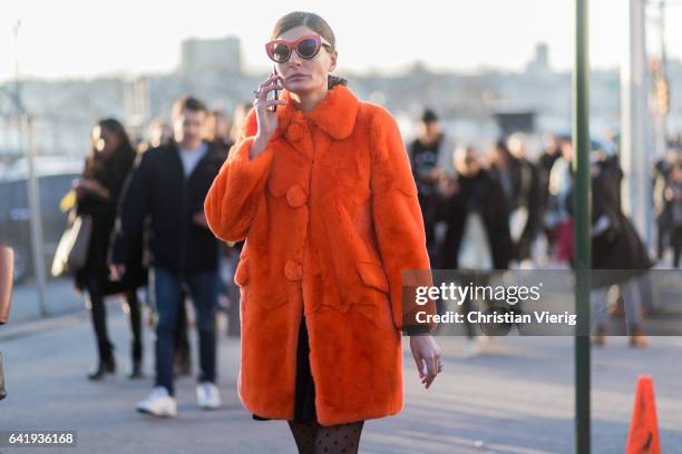 Giovanna Battaglia wearing an orange teddy coat, tights outside Coach on February 14, 2017 in New York City.