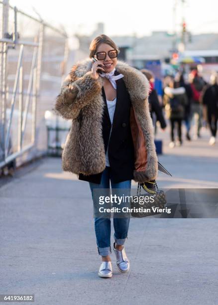 Guest wearing a fur coat, chanel bag outside Coach on February 14, 2017 in New York City.