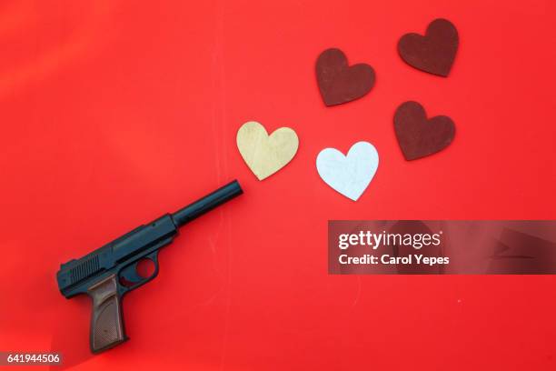 top view gun shooting/pointing hearts - love hate stock-fotos und bilder