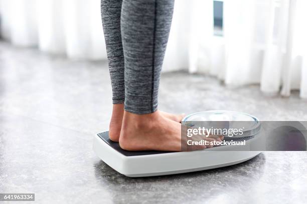 young healthy girl on home scales - mass unit of measurement stock pictures, royalty-free photos & images