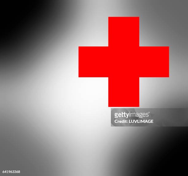 red cross on blurred greyish background. - red cross stock pictures, royalty-free photos & images