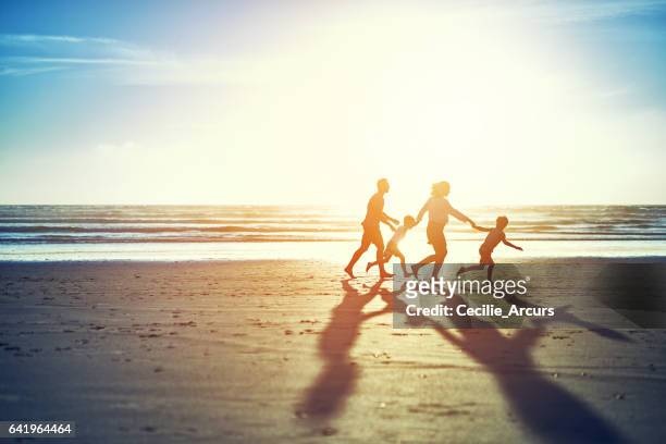 die sommersonne bringt spaß für die familie - running in the sun stock-fotos und bilder