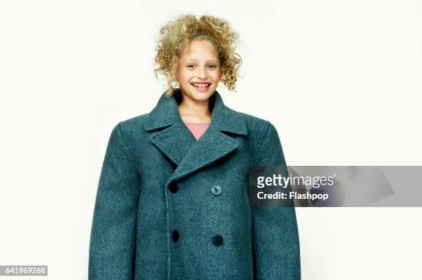 portrait of girl waving huge coat - young girl white background stock pictures, royalty-free photos & images