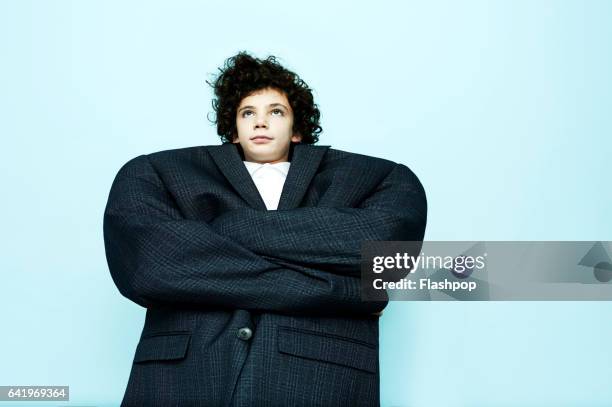 portrait of boy wearing big coat - demasiado grande fotografías e imágenes de stock