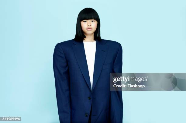 portrait of girl wearing huge business suit - adult imitation stock pictures, royalty-free photos & images