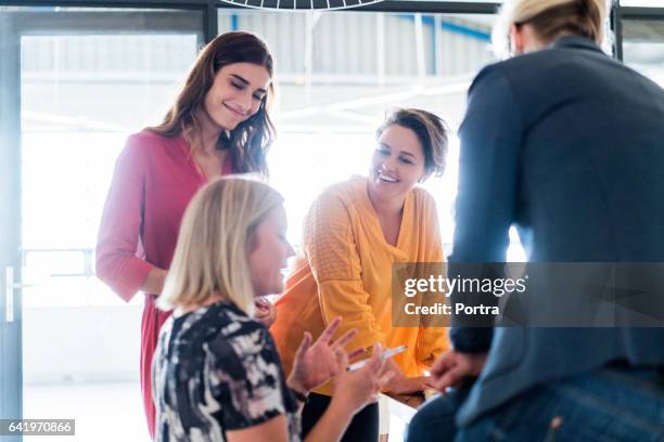 happy businesswomen looking at manager in office - sunny office stock pictures, royalty-free photos & images