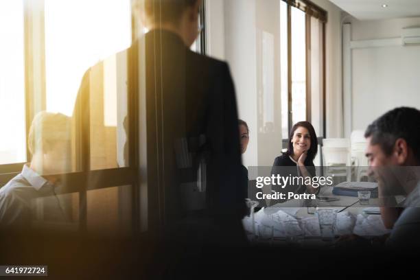 businesswoman giving presentation in board room - sunny office stock pictures, royalty-free photos & images