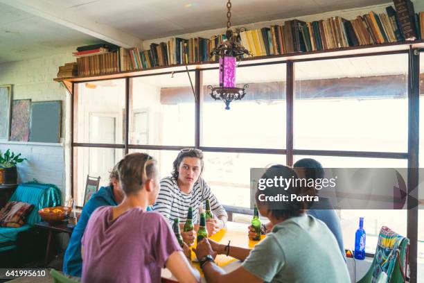jonge mannen luisteren naar vriend tijdens house party - alleen jonge mannen stockfoto's en -beelden
