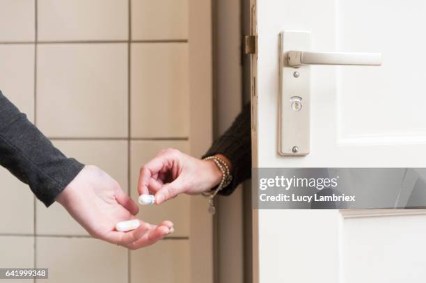 woman handing a tampon to other woman - tampon stock pictures, royalty-free photos & images