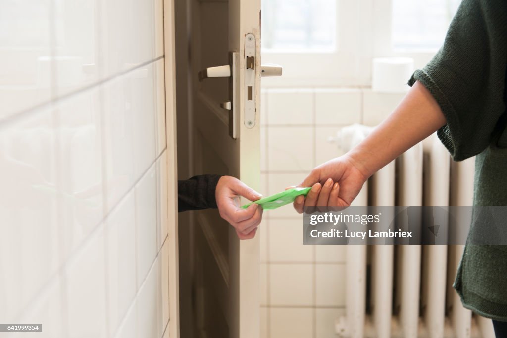 Woman handing sanitary pad to other woman